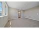 Neutral bedroom with carpeted floors, large window, and attached bathroom entrance at 4880 River Landing Ave, Firestone, CO 80504