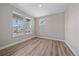 Well-lit bedroom with large windows, light-colored walls, and laminate wood flooring at 4880 River Landing Ave, Firestone, CO 80504