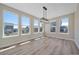Bright dining room with large windows, light wood floors, and modern chandelier at 4880 River Landing Ave, Firestone, CO 80504