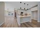 Modern kitchen features white cabinets, stainless appliances, and a quartz countertop island with pendant lighting at 4880 River Landing Ave, Firestone, CO 80504