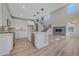 Open concept kitchen features white cabinets, stainless appliances, island, and view of the living room with fireplace at 4880 River Landing Ave, Firestone, CO 80504