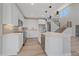 Bright, modern kitchen with stainless appliances, white cabinets, island, and staircase leading to upper level at 4880 River Landing Ave, Firestone, CO 80504