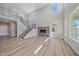 Open-concept living space featuring a modern fireplace, staircase, and abundant natural light at 4880 River Landing Ave, Firestone, CO 80504