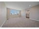 Spacious main bedroom featuring large windows and neutral carpeting leading into the attached bathroom at 4880 River Landing Ave, Firestone, CO 80504