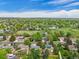 Scenic aerial view of a neighborhood with homes, pond, and lush trees under a cloudy blue sky at 13030 King Cir, Broomfield, CO 80020