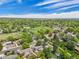 Wide aerial view of a vibrant neighborhood with homes and lush green trees under a cloudy blue sky at 13030 King Cir, Broomfield, CO 80020