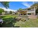 A large backyard featuring a patio, garden boxes, a green lawn, and perimeter fencing at 13030 King Cir, Broomfield, CO 80020