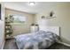 Cozy bedroom with a white bed frame, a leafy duvet, and natural light from a window at 13030 King Cir, Broomfield, CO 80020