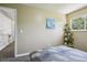 Serene bedroom features a sailboat painting and a ladder-style plant stand by the window at 13030 King Cir, Broomfield, CO 80020