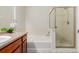 Well-lit bathroom with a combined tub and shower unit, vanity, and tiled floors at 13456 Via Varra # 224, Broomfield, CO 80020
