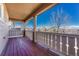 Inviting covered porch with wood flooring, charming railing, and a pleasant view at 5078 Zion Ct, Castle Rock, CO 80109