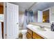 Clean bathroom featuring a shower-tub combo, wood vanity with chrome fixtures, and a large mirror at 3653 S Flanders St, Aurora, CO 80013