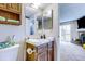 Well-lit bathroom with a wooden vanity, a single sink, and a mirrored cabinet with access to the living room at 3653 S Flanders St, Aurora, CO 80013