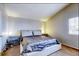 Light filled bedroom with neutral walls, plush carpet, side tables and large window for natural light at 3653 S Flanders St, Aurora, CO 80013