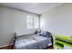 Cozy bedroom features neutral walls, a single bed, window and built-in shelving with drawer storage at 3653 S Flanders St, Aurora, CO 80013