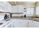 Efficient kitchen featuring white cabinetry, granite countertops, and stainless steel appliances with a bright window at 3653 S Flanders St, Aurora, CO 80013