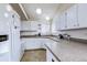 Bright kitchen with white cabinets, granite countertops, a window overlooking the backyard and tiled flooring at 3653 S Flanders St, Aurora, CO 80013