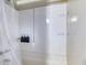 Brightly lit shower stall features a white surround with built in soap and shampoo shelving at 3653 S Flanders St, Aurora, CO 80013