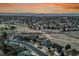 Expansive aerial view of a residential area, showcasing houses, open fields, walking paths, and a beautiful sky at 9845 Glenstone Trl, Highlands Ranch, CO 80130