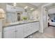 Bathroom featuring double sinks, granite countertops, white cabinets, and decorative plants at 9845 Glenstone Trl, Highlands Ranch, CO 80130
