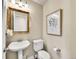 Stylish powder room with a pedestal sink and decorative mirror at 9845 Glenstone Trl, Highlands Ranch, CO 80130