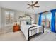 Bright bedroom with a ceiling fan, balcony, and large window with plantation shutters at 9845 Glenstone Trl, Highlands Ranch, CO 80130