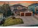 Charming two-story home with a manicured lawn and two-car garage, enhanced by a colorful dusk sky at 9845 Glenstone Trl, Highlands Ranch, CO 80130