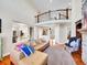 Open-concept living room with a second-story balcony and views of the kitchen and entryway at 9845 Glenstone Trl, Highlands Ranch, CO 80130