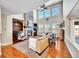 Spacious living room featuring a stone fireplace, hardwood floors and tall windows at 9845 Glenstone Trl, Highlands Ranch, CO 80130