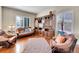 Inviting living room with hardwood floors, a built-in bookcase, and plenty of natural light at 9845 Glenstone Trl, Highlands Ranch, CO 80130