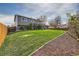 Manicured backyard featuring lush lawn, mature trees, and new wood fence at 16503 E Yale Pl, Aurora, CO 80013