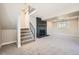 Finished basement with fireplace, neutral carpet, and stairs leading to the main floor at 16503 E Yale Pl, Aurora, CO 80013
