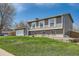 Low angle view of two-story home with front yard, garage, and neutral colored siding at 16503 E Yale Pl, Aurora, CO 80013