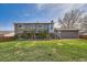 Back exterior view showcasing the home's siding, yard, and deck access at 16503 E Yale Pl, Aurora, CO 80013