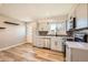 Modern kitchen with stainless appliances, spacious countertops, and warm wood-look laminate flooring at 16503 E Yale Pl, Aurora, CO 80013