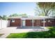 Backyard featuring a covered patio with a brick home and green grass perfect for outdoor entertaining and relaxation at 509 Newland St, Lakewood, CO 80226