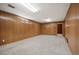 Spacious finished basement with wood paneling, carpet, and bright lighting offering versatility for recreation or additional living space at 509 Newland St, Lakewood, CO 80226