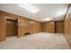 Large finished basement featuring carpet and wood paneling with a doorway to another room offering flexible living space at 509 Newland St, Lakewood, CO 80226