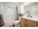 Bright bathroom featuring a modern vanity, tub with shower, and neutral finishes, offering a clean and functional space at 509 Newland St, Lakewood, CO 80226
