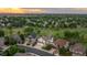 Stunning aerial view of a beautiful neighborhood with mature trees and well-maintained homes under a colorful sky at 16667 Tin Cup Ct, Parker, CO 80134