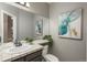Well-lit half bathroom with tiled countertop, decorative mirror, and elegant artwork at 16667 Tin Cup Ct, Parker, CO 80134