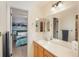 Bright bathroom with double sinks, a large mirror, and a view into an adjacent bedroom at 16667 Tin Cup Ct, Parker, CO 80134
