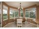 Bright breakfast nook featuring a round wooden table, white chairs, lots of windows, and views of the backyard at 16667 Tin Cup Ct, Parker, CO 80134
