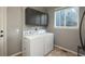 A functional laundry room with gray cabinets, a window, and a washer and dryer at 16667 Tin Cup Ct, Parker, CO 80134
