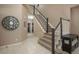 Entryway stairway with carpeted steps, white railings, neutral walls, tiled floor, and decorative mirror accent at 16667 Tin Cup Ct, Parker, CO 80134