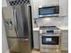 Stainless steel appliances including refrigerator, oven, and microwave in renovated kitchen at 2737 N Marion St, Denver, CO 80205