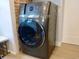 Modern gray washer and dryer with smart features next to exposed brick wall at 2737 N Marion St, Denver, CO 80205
