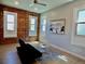 Light-filled living room with exposed brick wall, beach art, modern furniture, and ceiling fan at 2737 N Marion St, Denver, CO 80205
