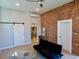 Open-concept living room with exposed brick wall, sliding barn door, and modern furniture at 2737 N Marion St, Denver, CO 80205