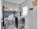 Functional laundry room featuring modern Samsung washer and dryer set, stylish wallpaper, and wooden shelving at 545 W 174Th Pl, Broomfield, CO 80023